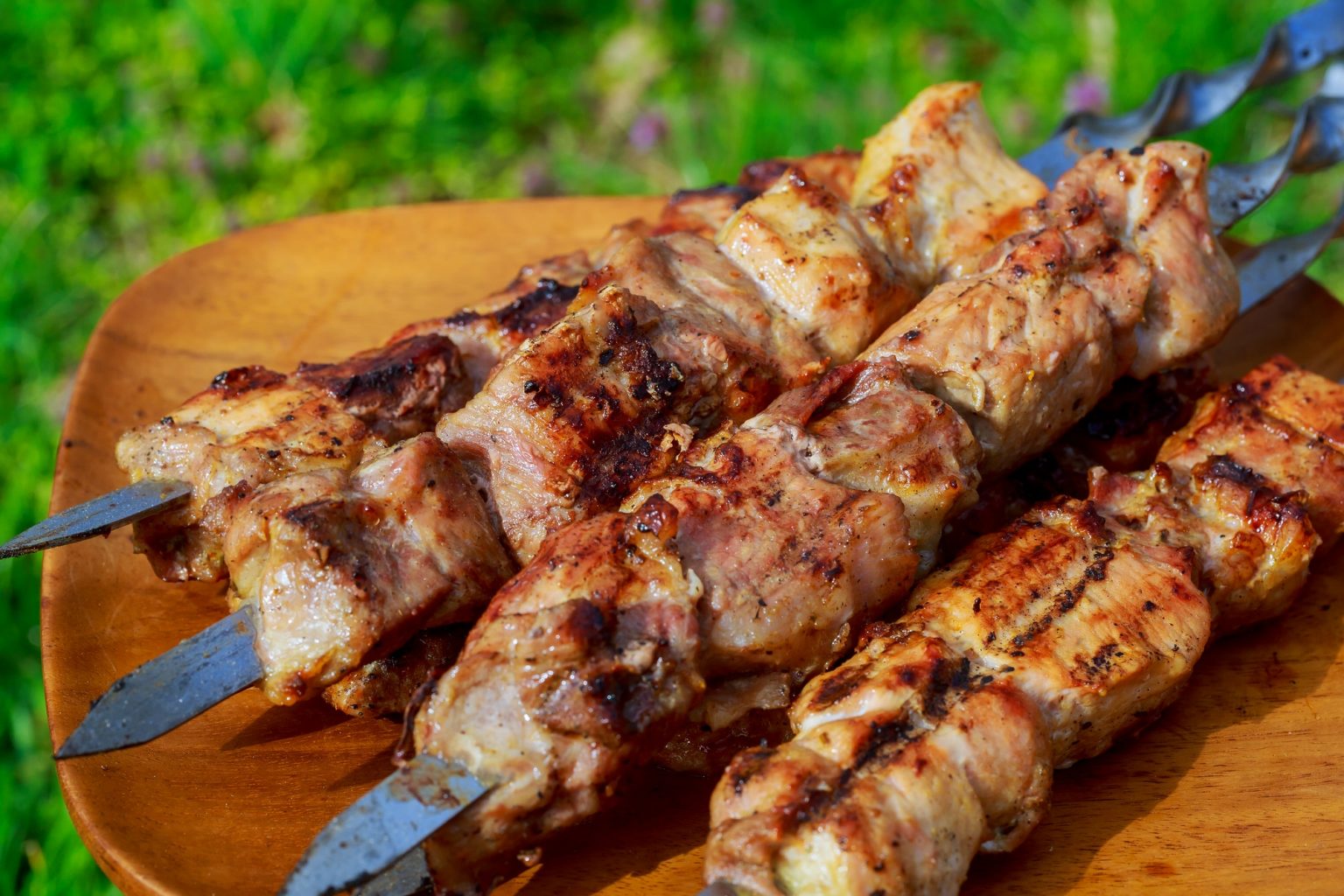 closeup of some meat skewers being grilled in a barbecue